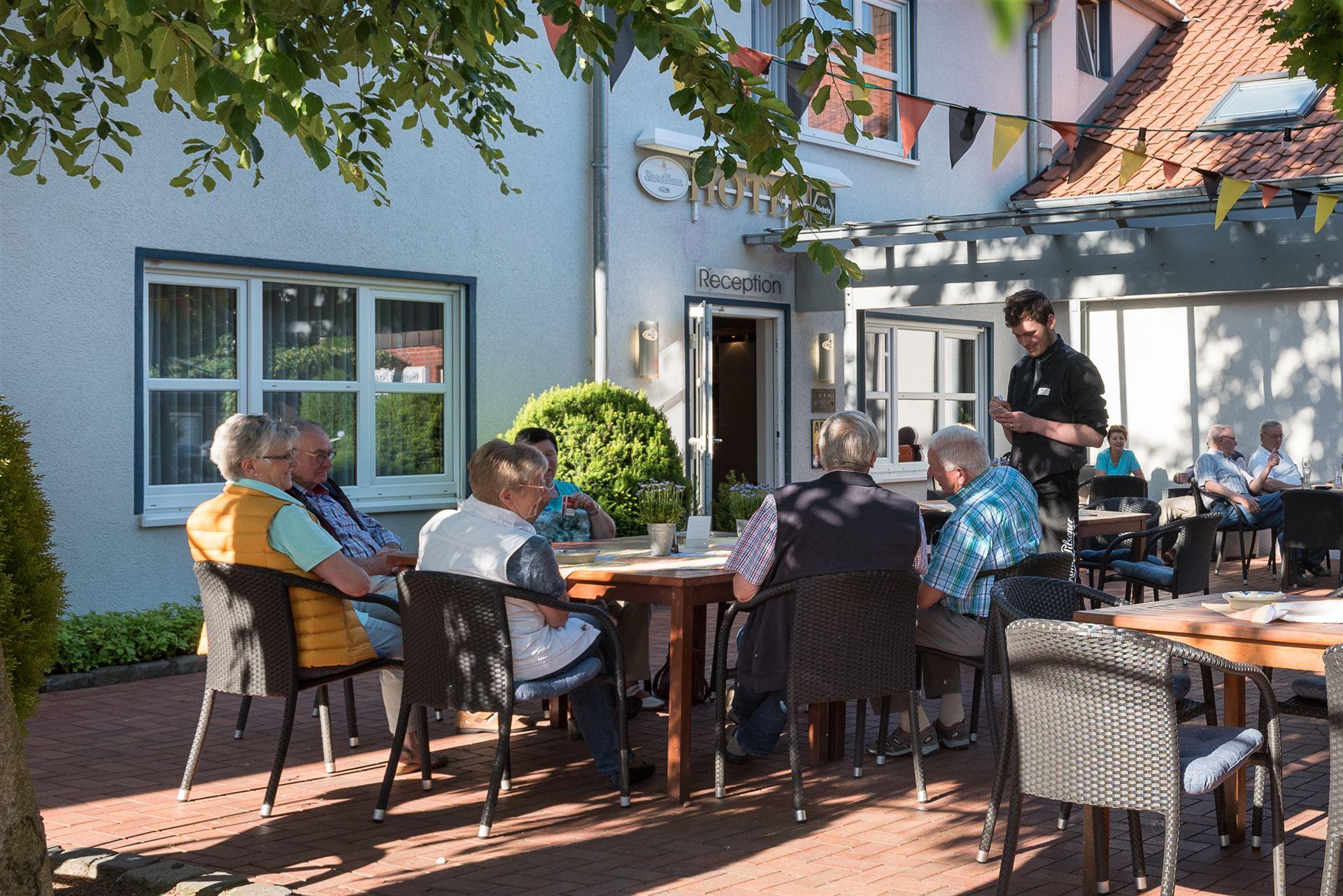 Guests in the beer garden ordering drinks from the waiter.