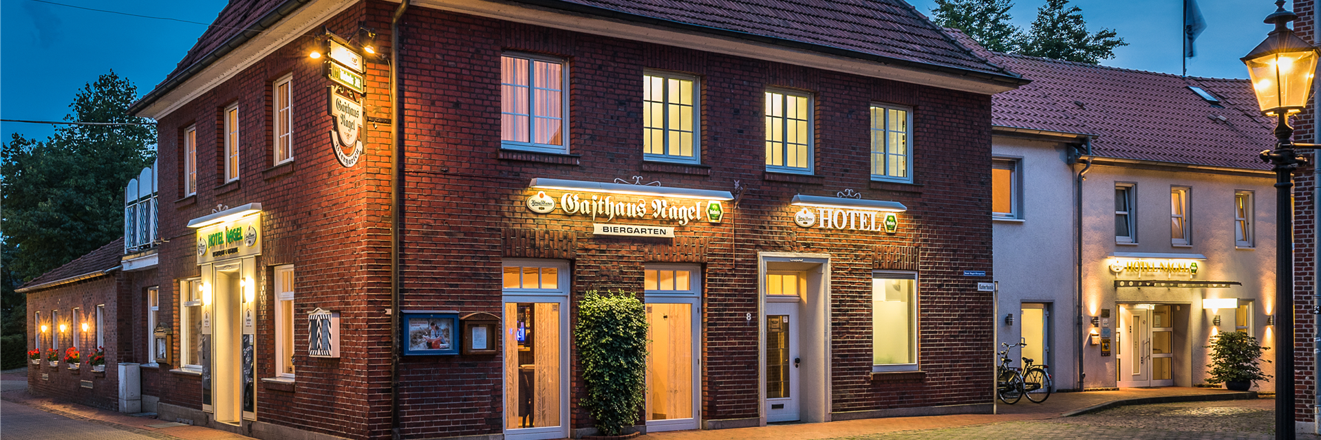 Exterior view of the hotel in the evening, seen from the church.