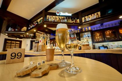 Close-up of the bar counter with a glass of König Pilsener and a liqueur from Sasse Distillery.