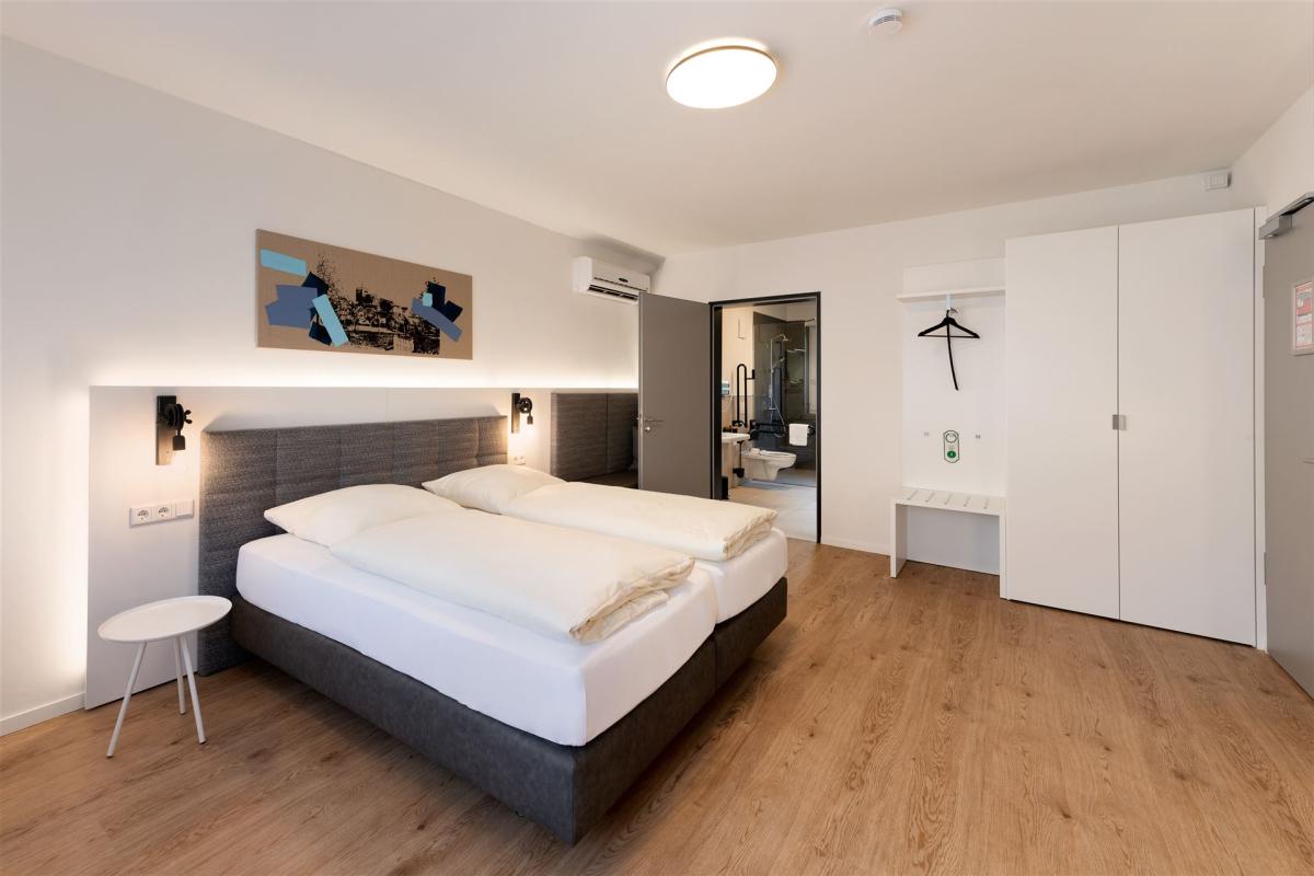 View of a comfort double room with bathroom in the background