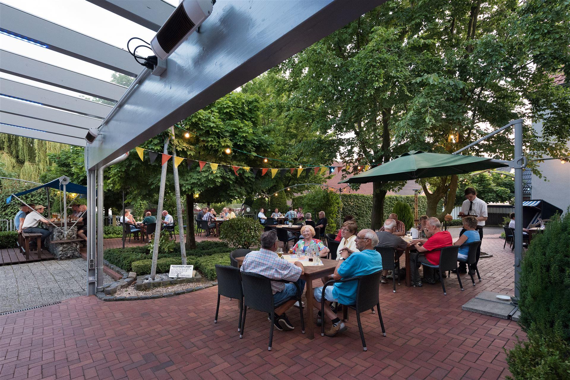 Photo shows the beer garden with guests, photographed from the hotel’s rear entrance.