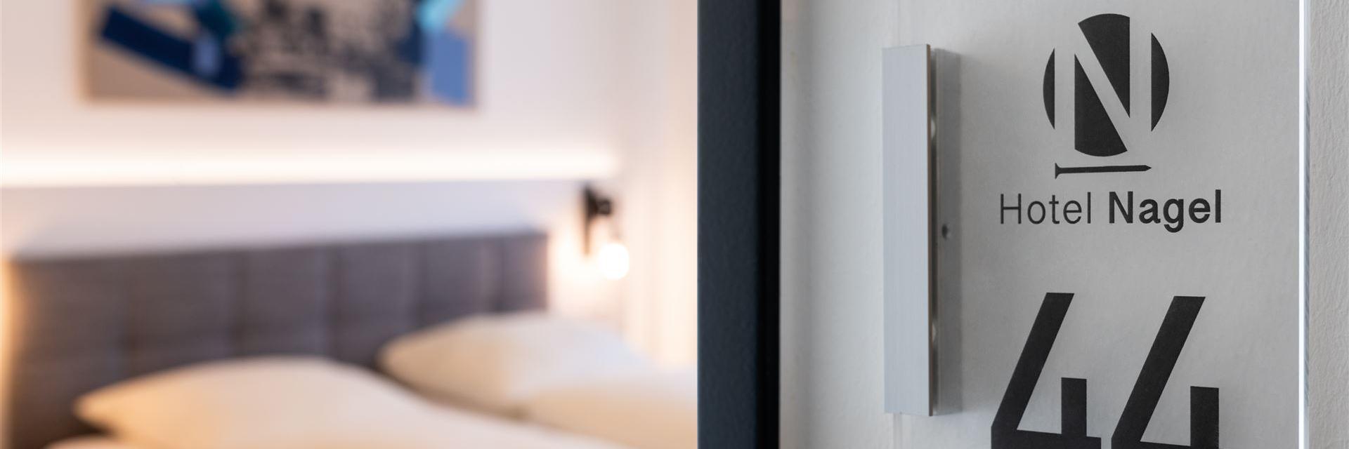 Close-up of a room number with the room blurred in the background.