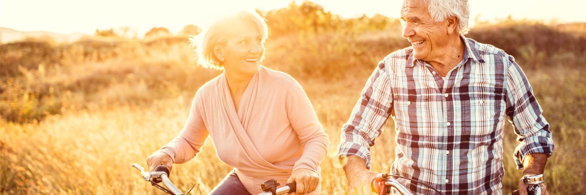 An older couple cycling in beautiful weather.